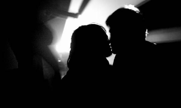 Hombre y mujer besándose con poca luz